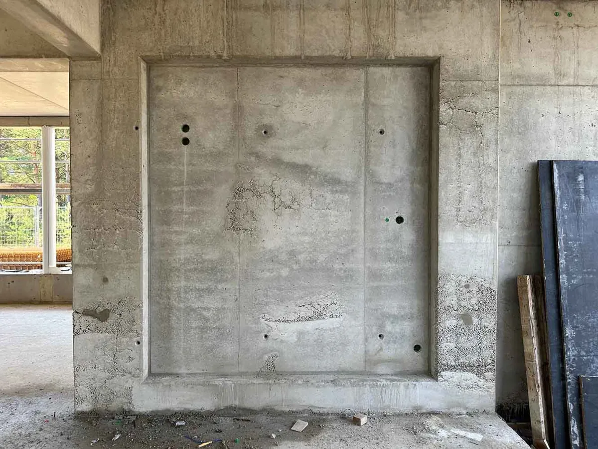 Kiesnest in einer Sichtbetonwand vor der Bearbeitung